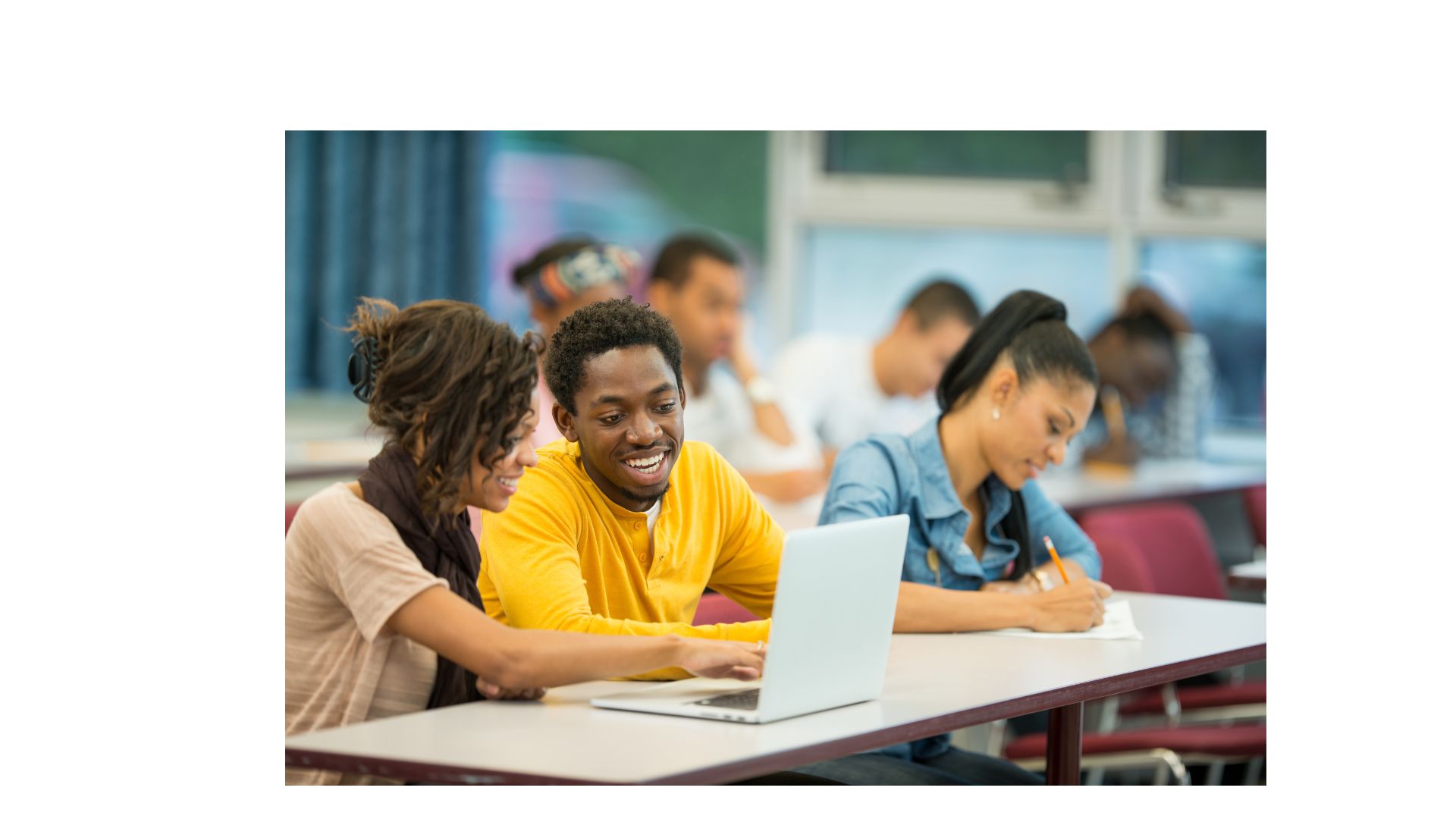two students smiling and talking in classroom