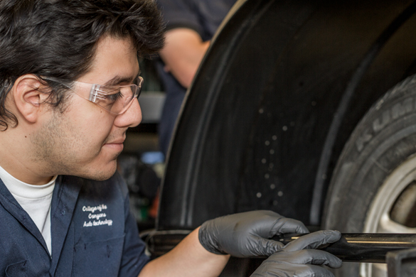 Auto mechanic student working on car. 