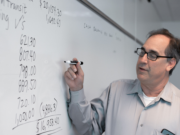 Buisness instructor in class working on projects. 