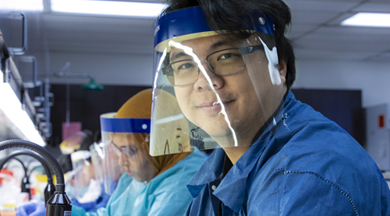 CLS students in lab coats and splash masks. 