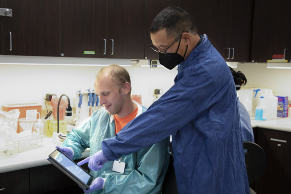 Clinical Laboratory Scientist student getting help from instructor in lab class. 
