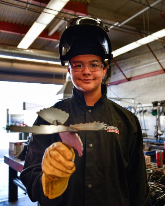 Welding student with metal bird