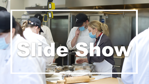 Student chefs with Instructor Chef Cindy Schwanke preparing food. 