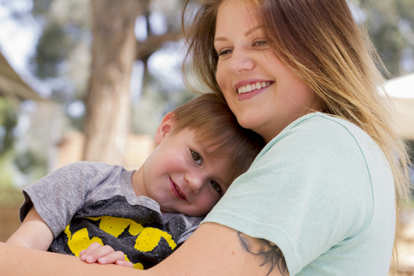 Faculty hugging child at Center for Early Childhood Education. 