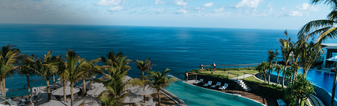 Ocean view Hotel &amp; Restaurant under a blue sky.