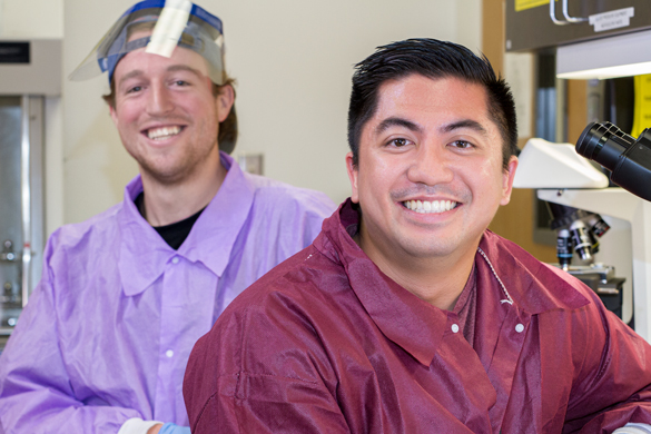 Medical Laboratory Technician students with microscopes.