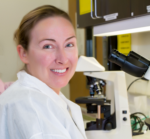 Medical Laboratory Technician student at microscope in lab.