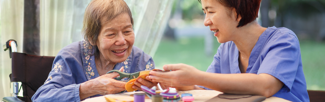 Asian OTA woman helping an Asian elderly woman.