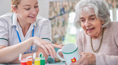 OTA helping older woman with cup.