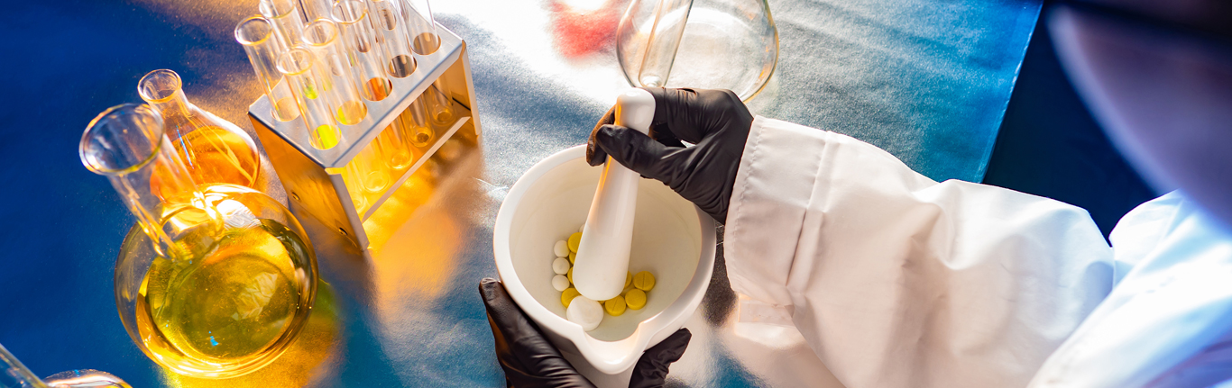 Tablets. Lab technician grinds multi-colored pills. The concept is the preparation of prescription drugs. Creation of individual medicines. The workflow of the medical laboratory