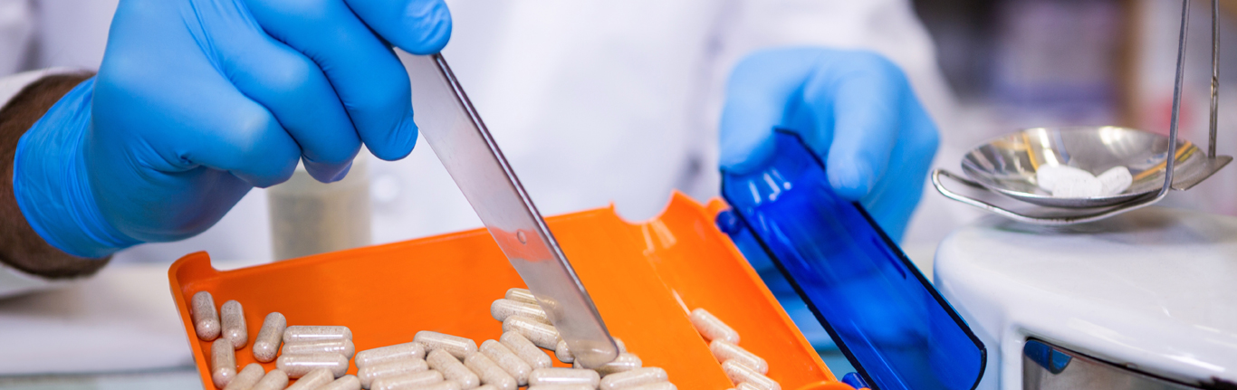 Pharmacist putting pills in container.