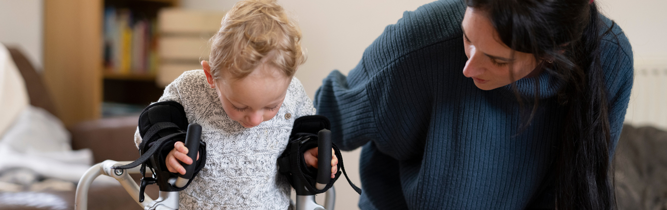 Mother assisting son with cerebral palsy.