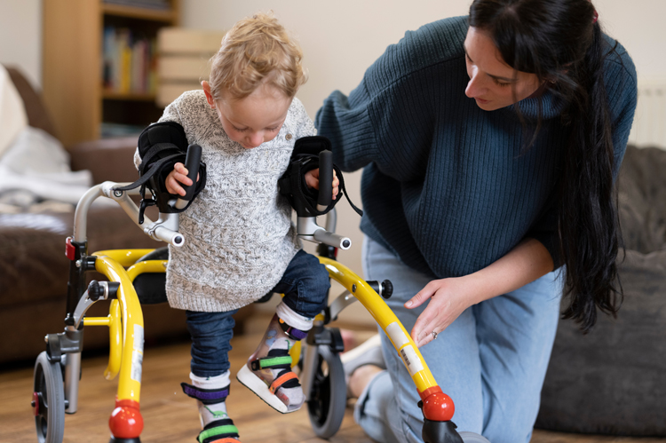 Mother assisting son with cerebral palsy.