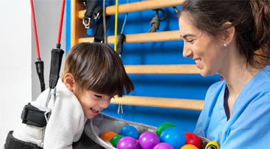 Cute kid with cerebral palsy doing musculoskeletal therapy in the hospital.