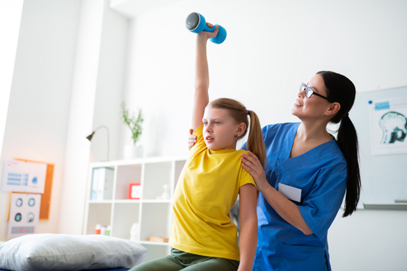 Physical Therapist assisting a young girl in stretching.