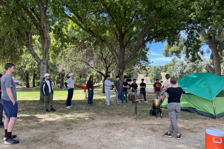 Students standing under trees receiving Recreation Management instruction.
