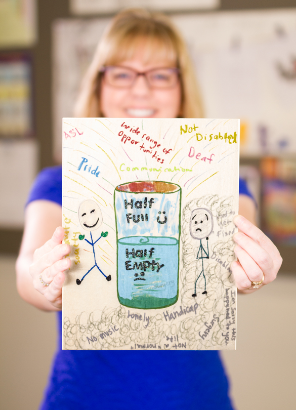 ASL faculty holding art sign