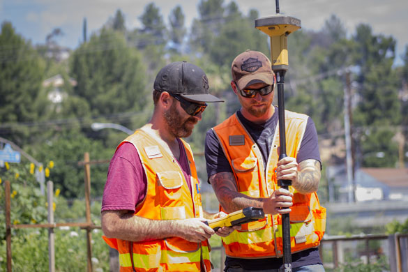 Students looking through surveyor equipment at College of the Canyons. 