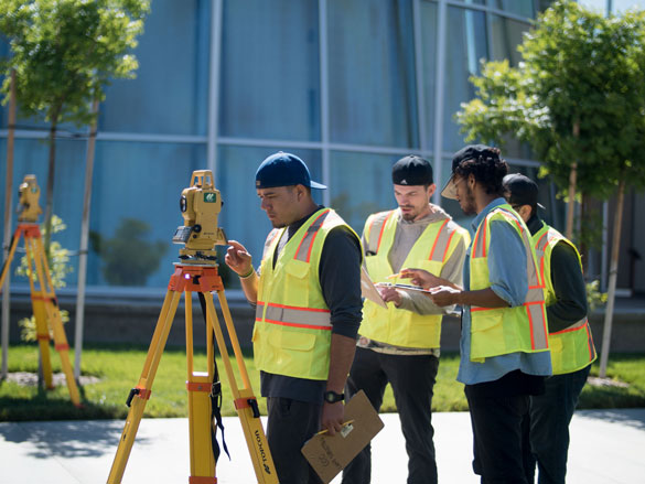 Students looking through surveyor equipment at College of the Canyons. 