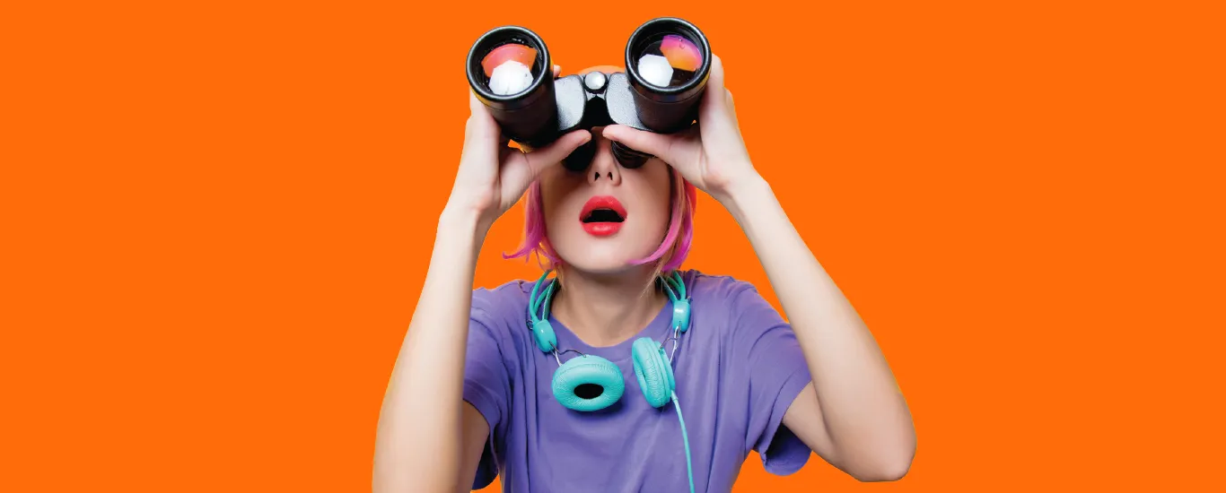 A young woman looks skyward with binoculars.