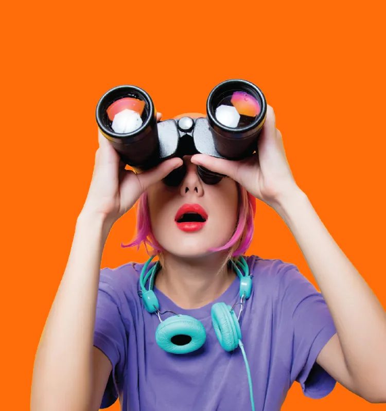 A young woman looks skyward with binoculars.