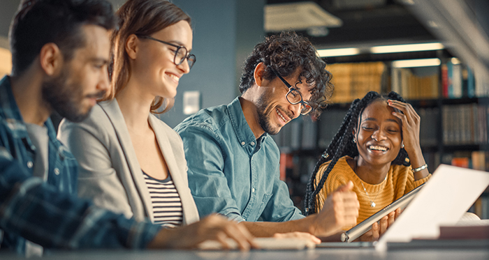 A diverse group of students work in a classroom.