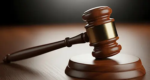 A wooden gavel rests atop a table.