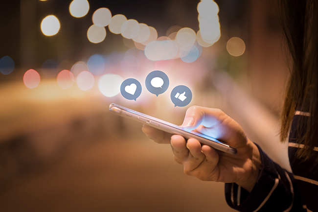 Composite illustration of a hand accessing social media on a smartphone.