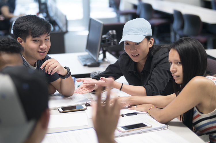 Group of students at a table problem solving.