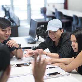 Group of students at a table problem solving.