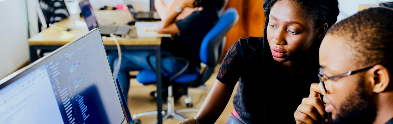Instructor with student at computer.