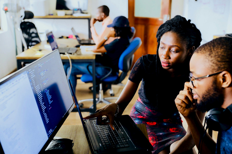 Instructor with student at computer.