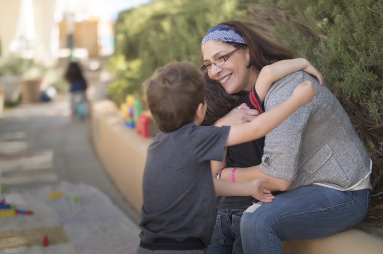 Children hugging their teacher at Early Childhood Education.